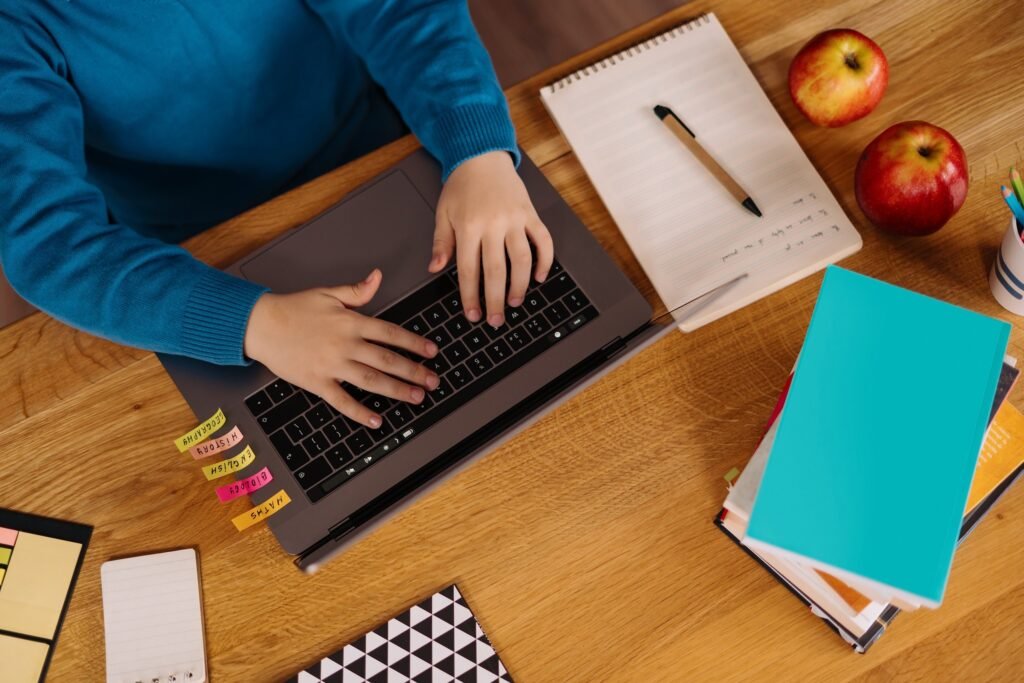 preteen boy uses laptop make online classes